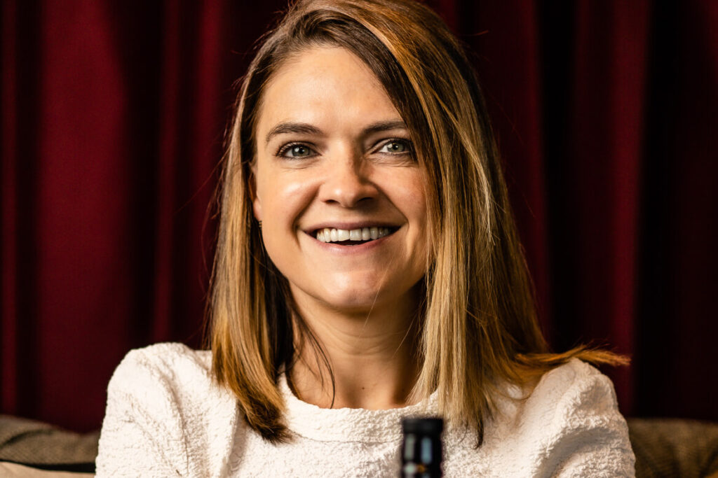 Cara Laing, Enkelin des Firmengründers von Douglas Laing & Co, auf der Couch mit einer Flasche Spirit auf dem Schoß