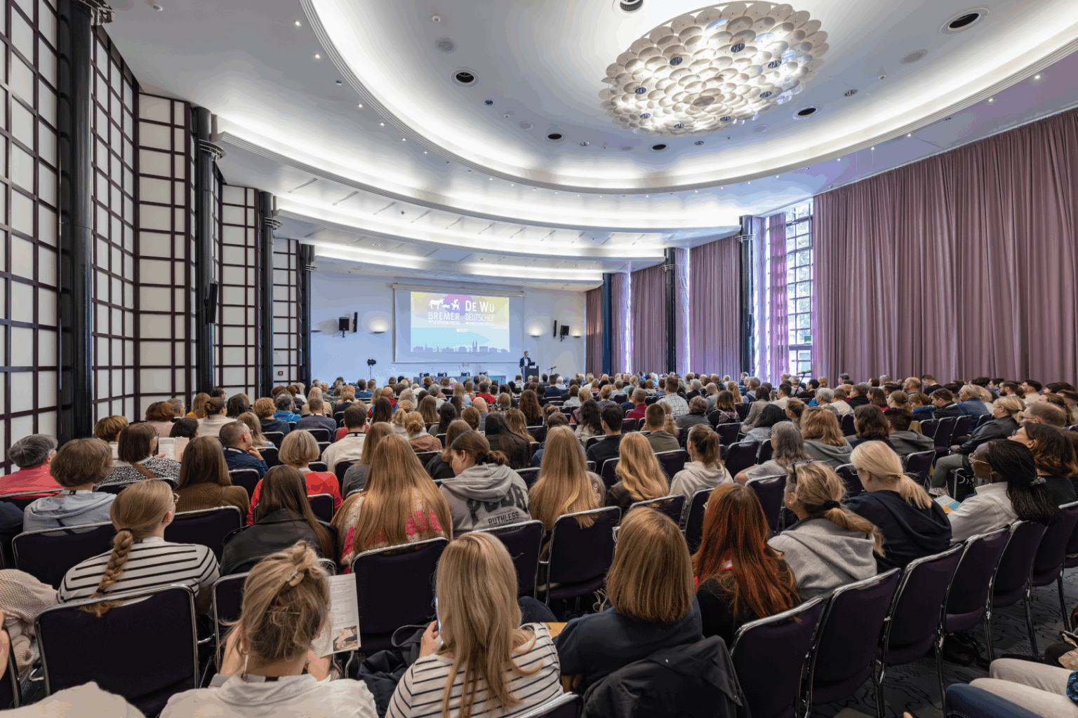 Großer Vortragssaal beim DEWU Deutschen Wundkongress mit zahlreichen Teilnehmenden, die gespannt einem Vortrag folgen.